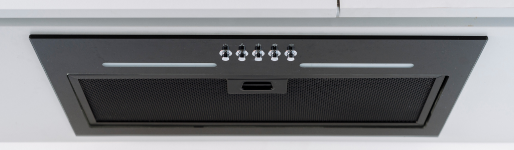 Kitchen range hood built in under white minimalistic cupboard