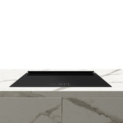 Black induction cooktop on a white marble countertop